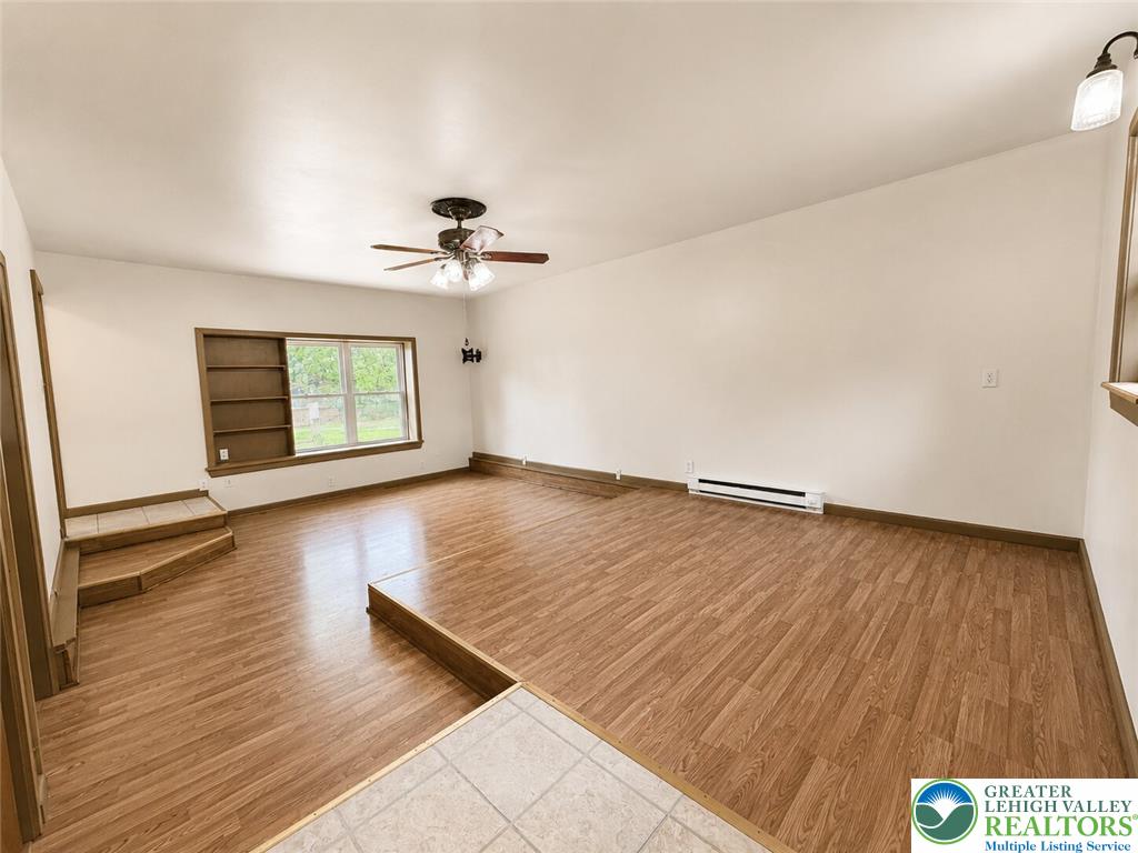 4995 Mountain Road Slatington, PA 18080 - Photo 12 of 30 A well-lit living area features built-in shelving, durable laminate flooring, and an efficient ceiling fan.