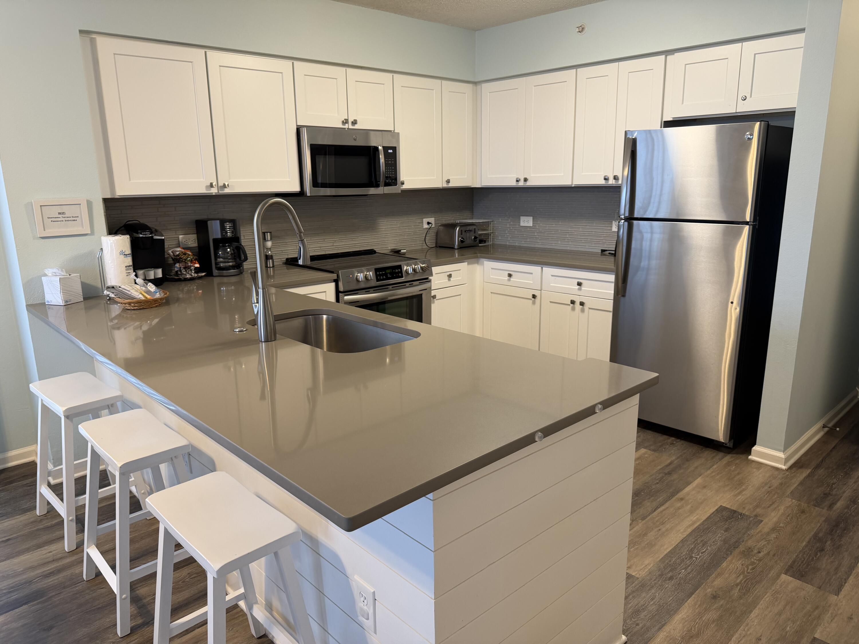 970 Highway 98, Unit 301 Destin, FL 32541 - Photo 6 of 18 a kitchen with a refrigerator a stove a sink and a microwave