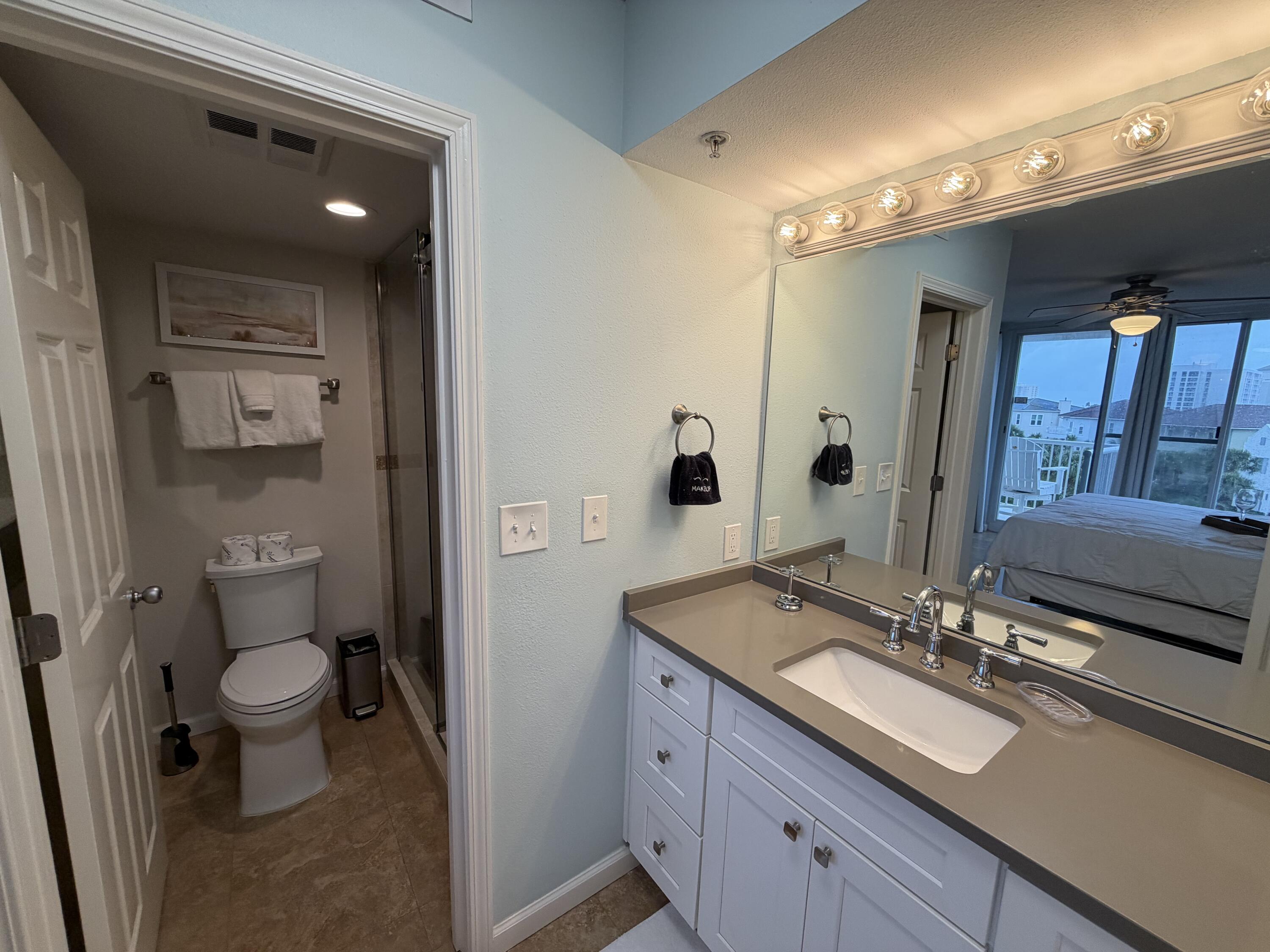 970 Highway 98, Unit 301 Destin, FL 32541 - Photo 9 of 18 a bathroom with a sink a toilet a shower and a mirror