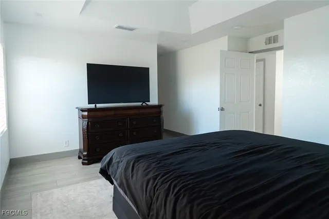 a bedroom with a bed and a flat screen tv