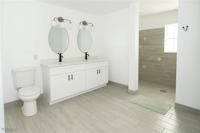 a bathroom with a toilet sink and mirror