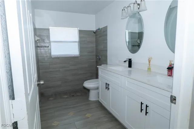 a bathroom with a toilet sink and mirror