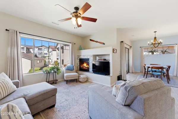 a living room with furniture fireplace and a large window