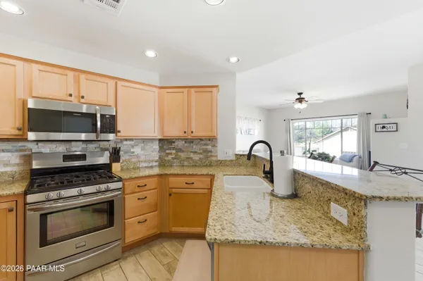 a kitchen with granite countertop a stove and a sink