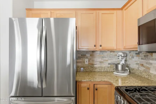 a kitchen with stainless steel appliances granite countertop a refrigerator and a stove