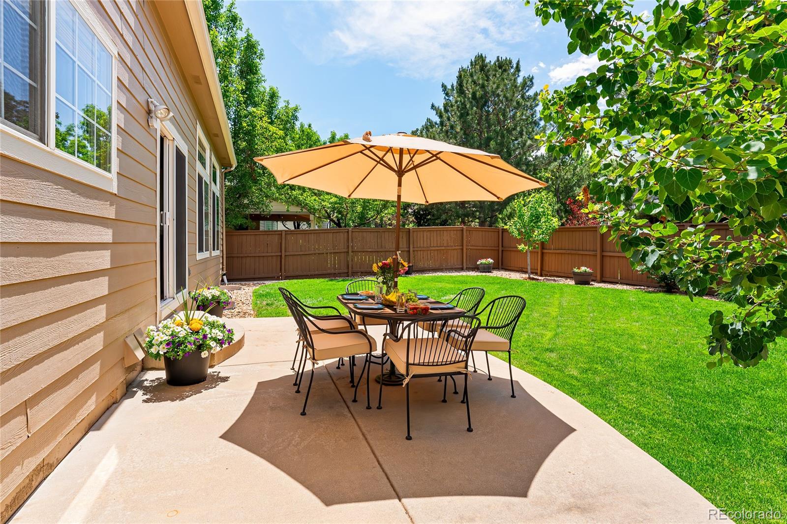 9441 South Hackberry Lane Highlands Ranch, CO 80129 - Photo 6 of 50 a lawn chair sitting under a blue umbrella