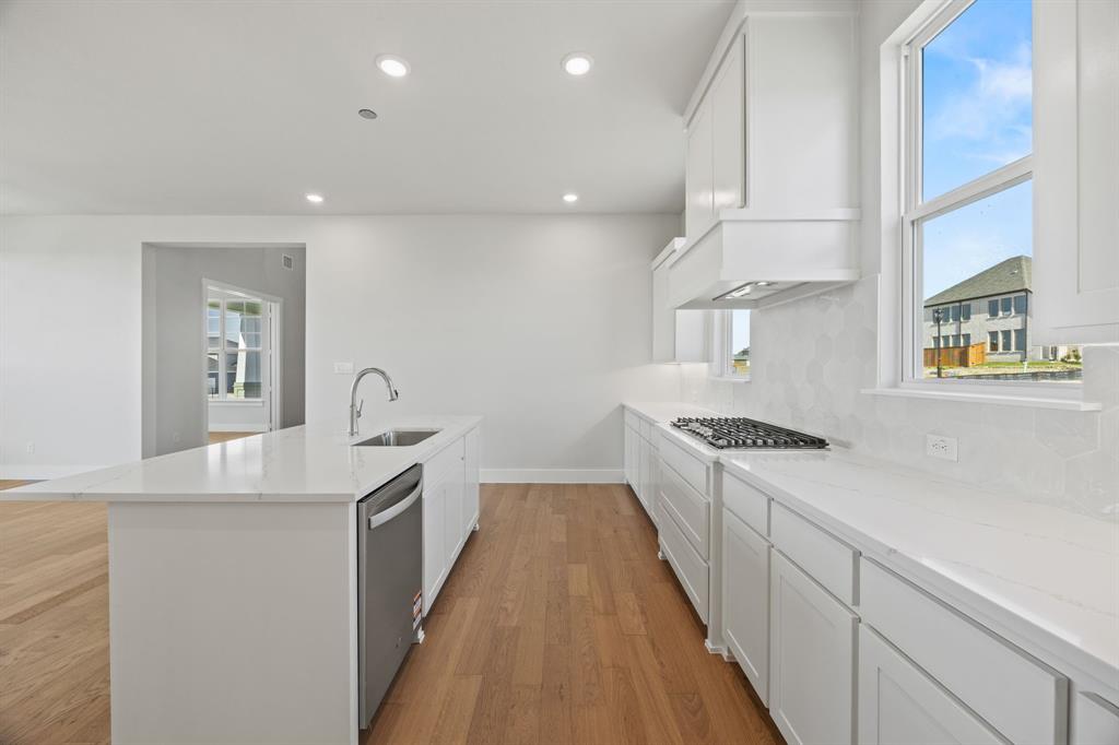 505 Callum Parkway Celina, TX 75009 - Photo 11 of 34 a kitchen with stainless steel appliances granite countertop a sink and a stove top oven