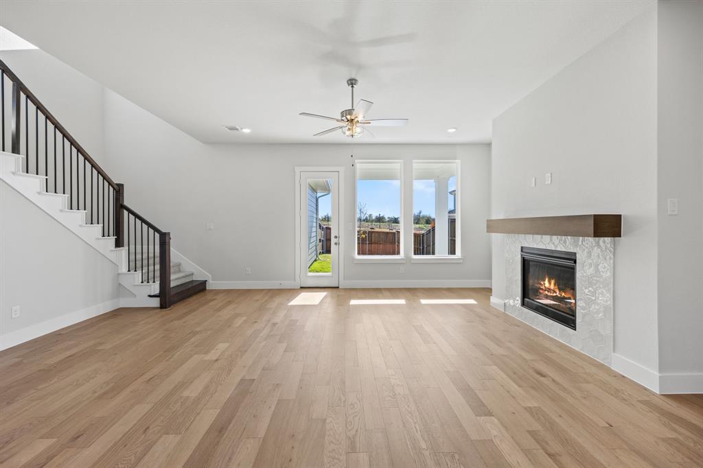 505 Callum Parkway Celina, TX 75009 - Photo 14 of 34 a view of an empty room with wooden floor fireplace and a window