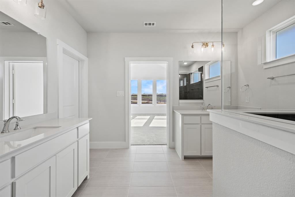 505 Callum Parkway Celina, TX 75009 - Photo 30 of 34 a bathroom with a sink a tub and mirror