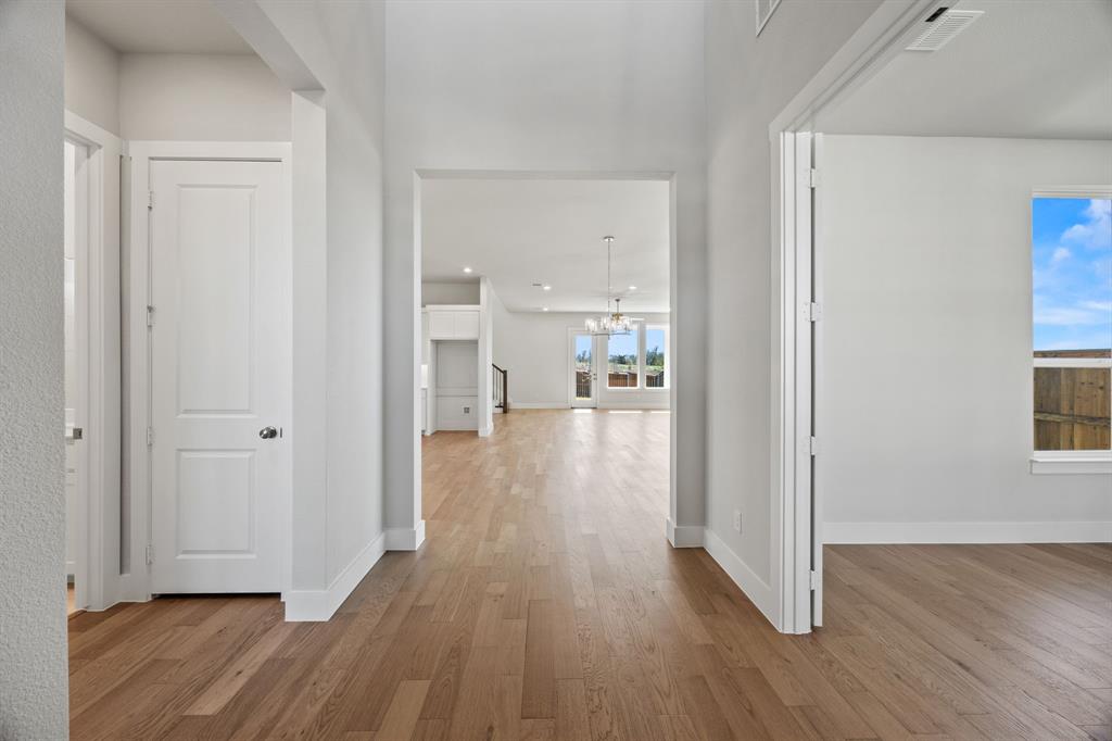 505 Callum Parkway Celina, TX 75009 - Photo 4 of 34 a view of a hallway with wooden floor a glass table and chairs
