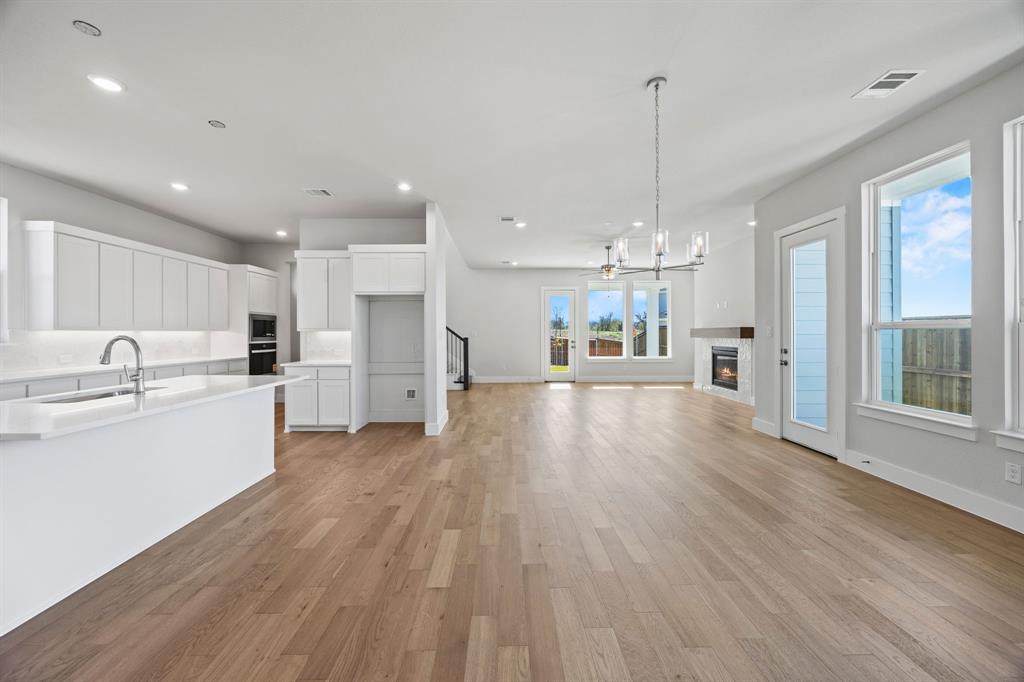 505 Callum Parkway Celina, TX 75009 - Photo 6 of 34 a view of a kitchen with refrigerator microwave and wooden floor