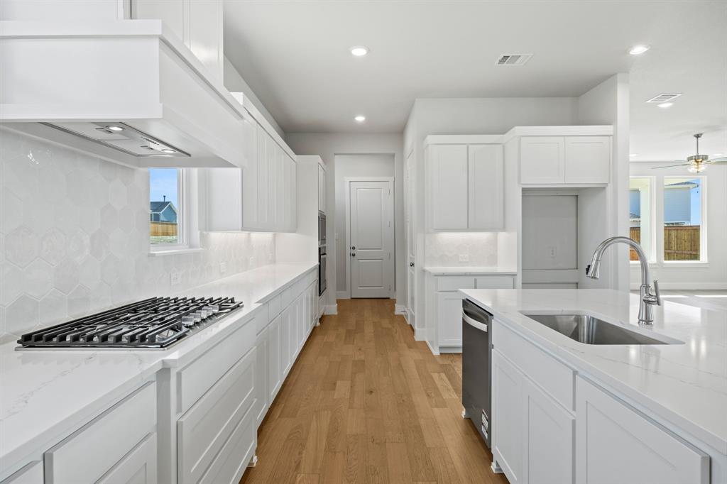 505 Callum Parkway Celina, TX 75009 - Photo 9 of 34 a large kitchen with stainless steel appliances granite countertop a sink and cabinets