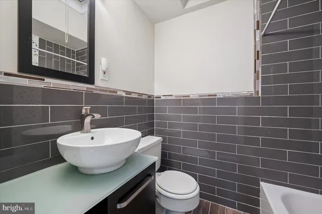 a bathroom with a toilet a sink and mirror
