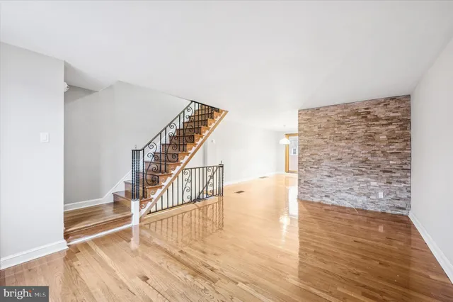 a view of entryway and hall with wooden floor