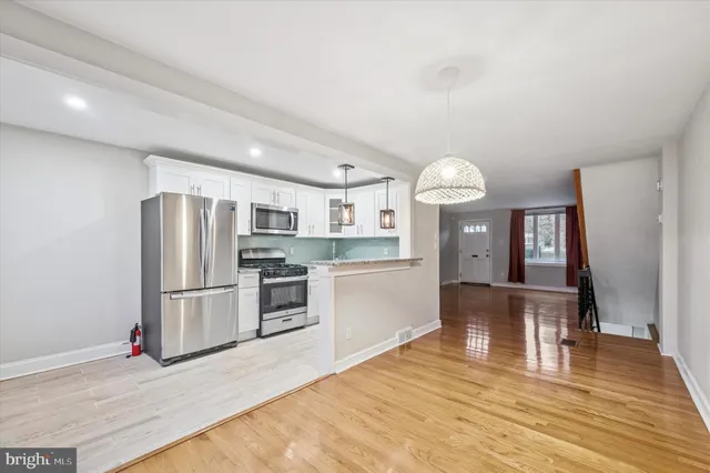 a kitchen with stainless steel appliances granite countertop a refrigerator and a stove top oven