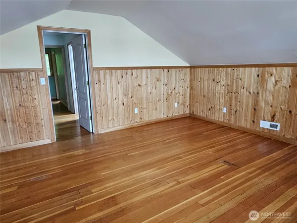 a view of an empty room with wooden floor