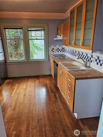 a hallway view with wooden floor and a window