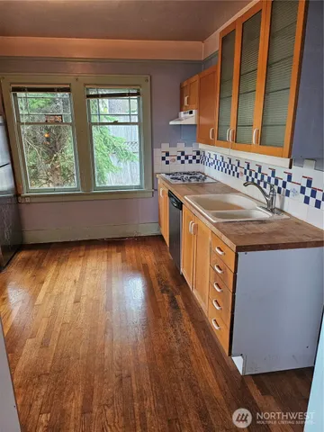 a hallway view with wooden floor and a window
