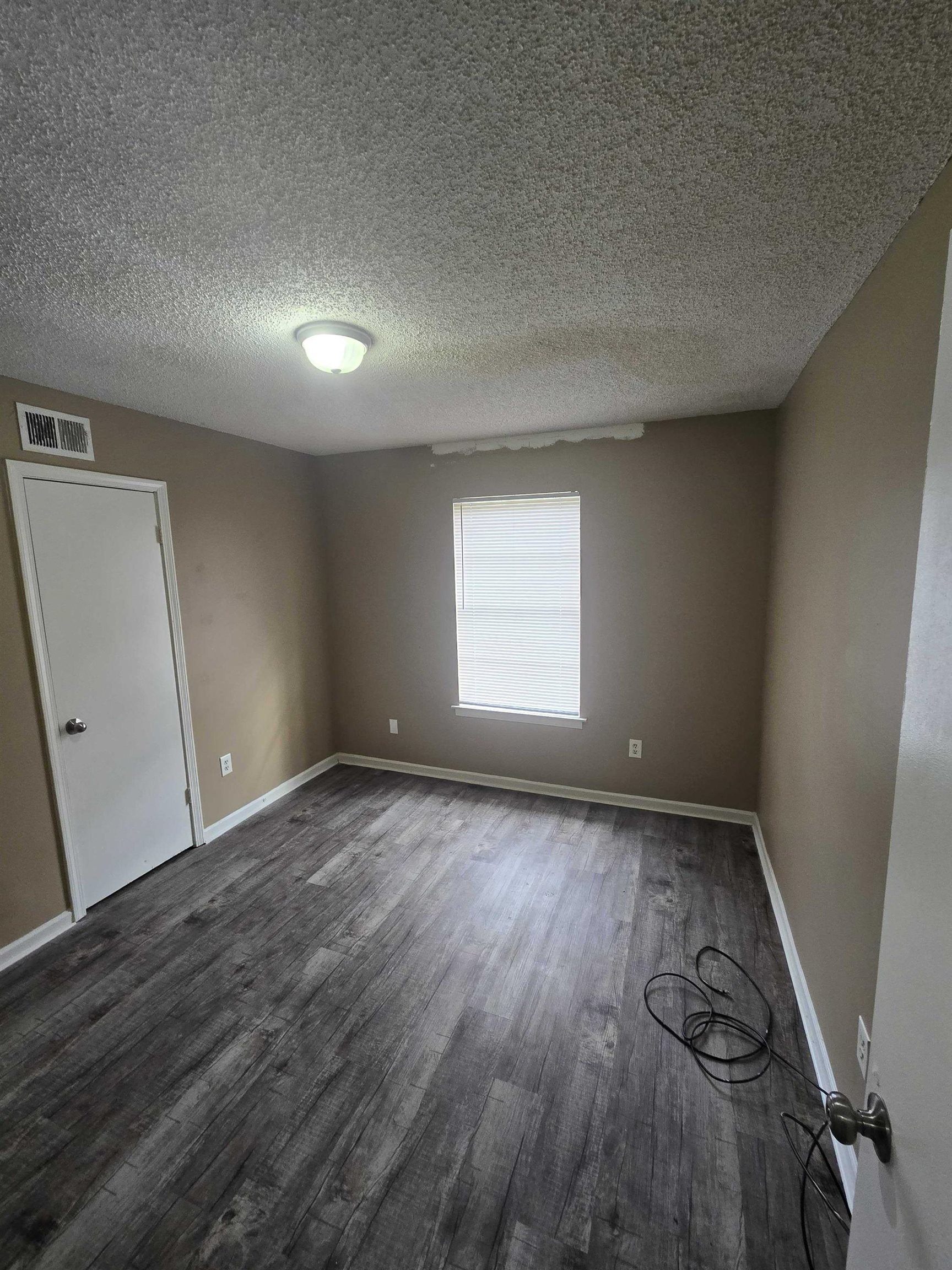 4511 Sumners Wells Road Memphis, TN 38118 - Photo 4 of 8 an empty room with wooden floor and windows