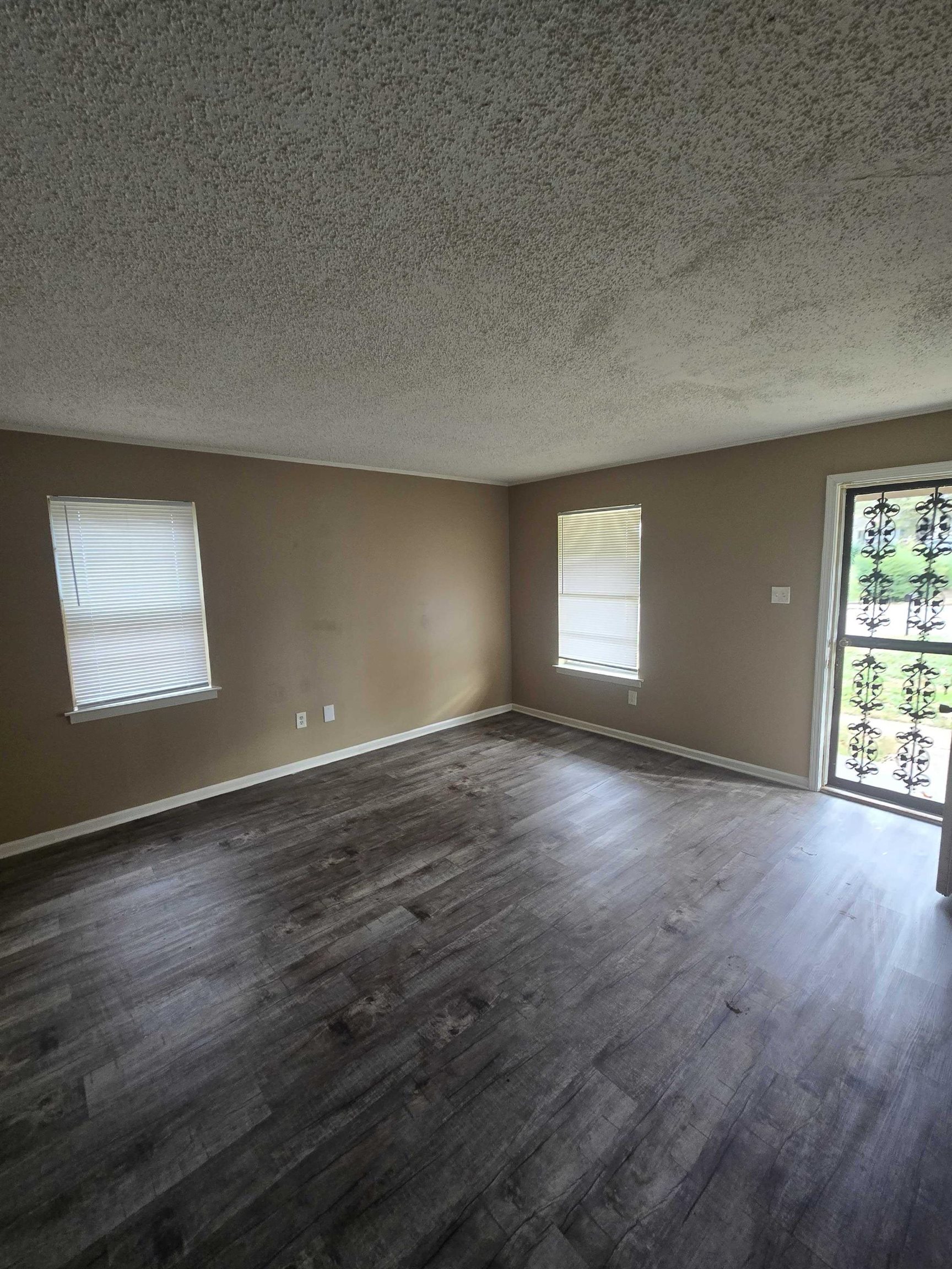 4511 Sumners Wells Road Memphis, TN 38118 - Photo 7 of 8 an empty room with wooden floor and windows