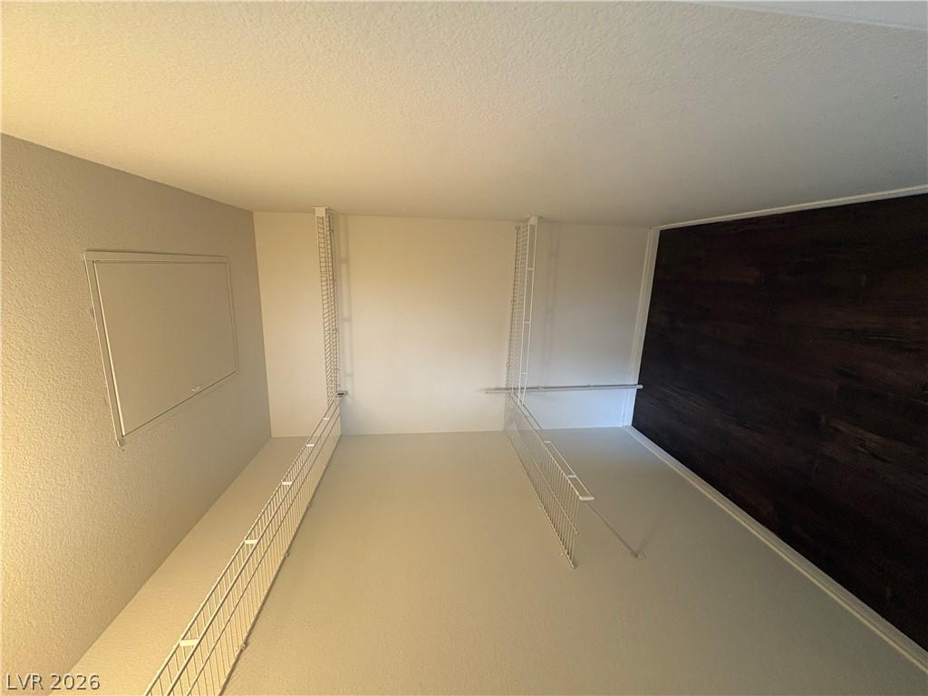 7255 West Sunset Road, Unit 2023 Las Vegas, NV 89113 - Photo 19 of 24 An organized walk-in closet features built-in wire shelving and a textured accent wall.