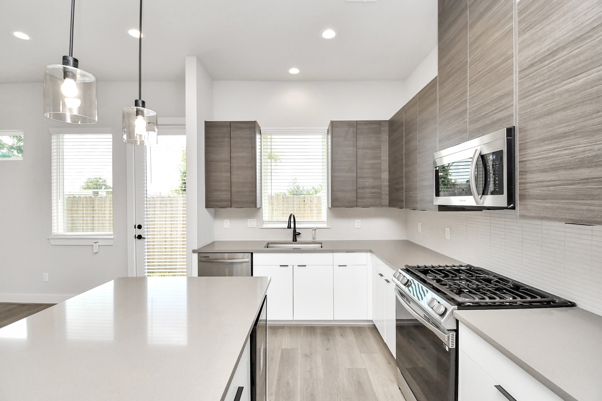 313 Charlock Street Houston, TX 77022 - Photo 11 of 34 This modern kitchen features sleek cabinetry, stainless steel appliances, and ample natural light. It has a spacious design with an island, pendant lighting, and large windows overlooking the backyard.