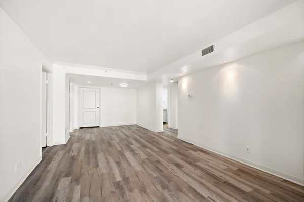 a view of empty room with wooden floor