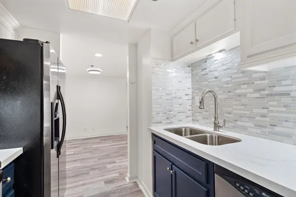 a kitchen with stainless steel appliances kitchen island a sink refrigerator and microwave