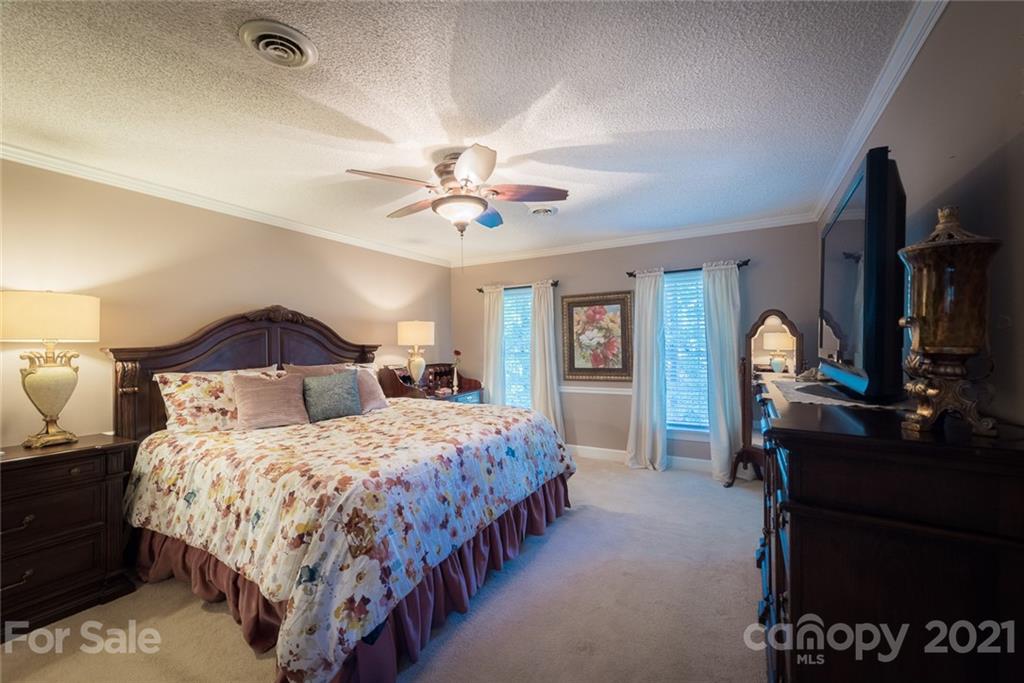 131 Friendfield Drive Fort Mill, SC 29715 - Photo 31 of 46 a bedroom with a bed and a chandelier