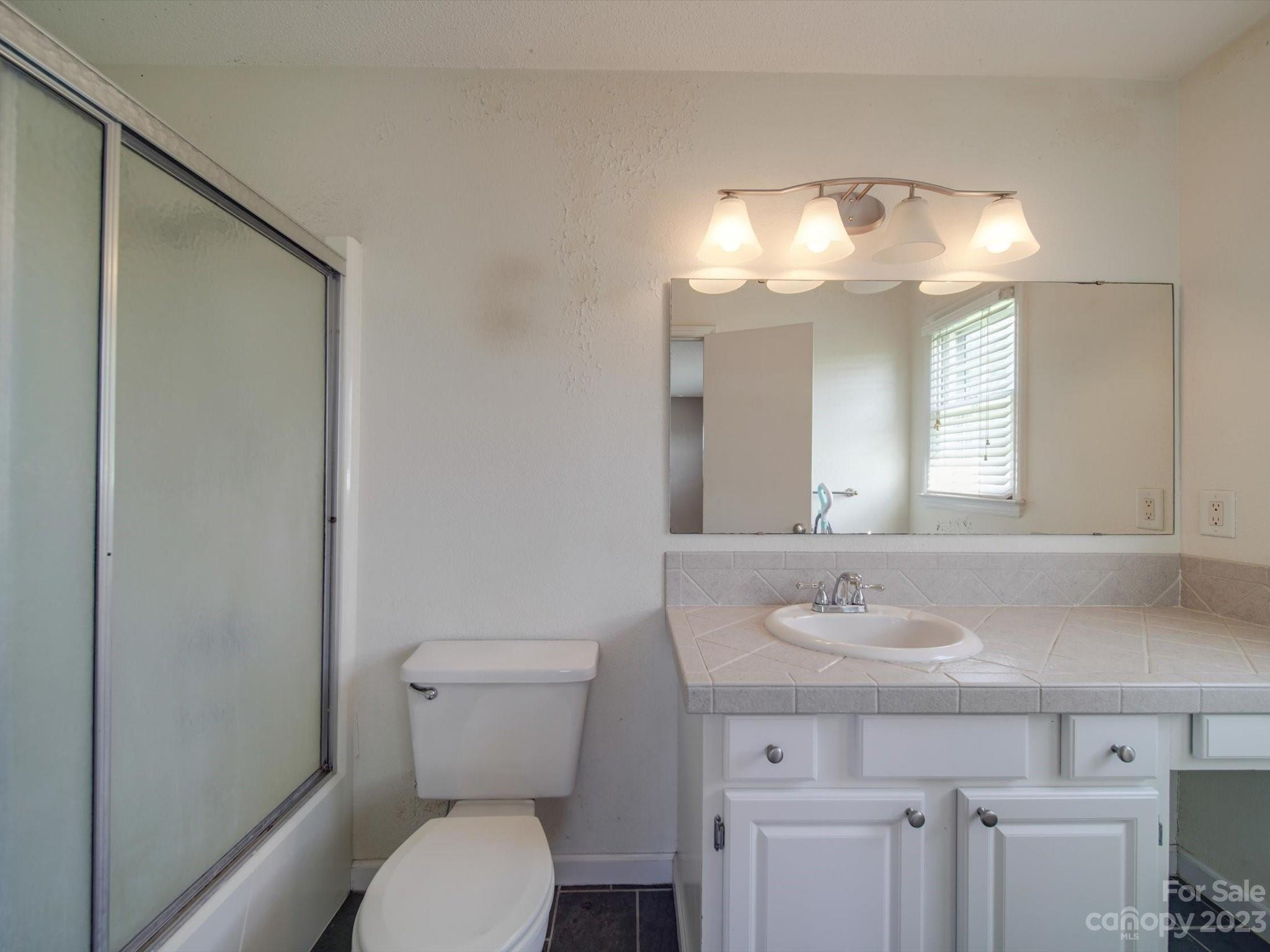 1004 Austin Chaney Road Wingate, NC 28174 - Photo 40 of 48 a bathroom with a toilet sink and mirror