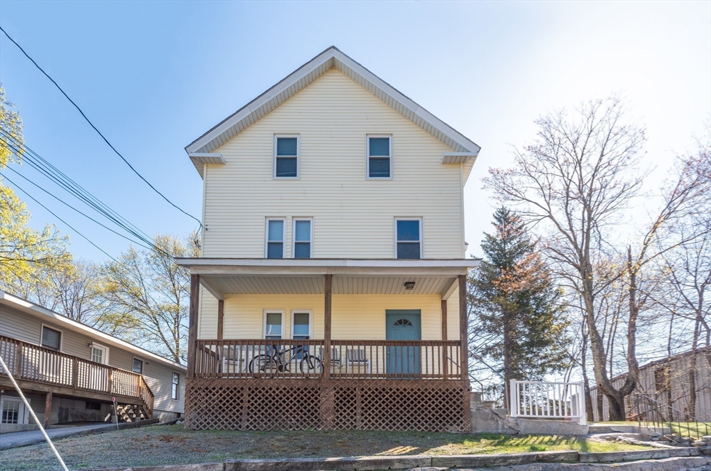 21 Maple Street Clinton, MA 01510 - Photo 2 of 17 a view of a white house with large windows and a outdoor space