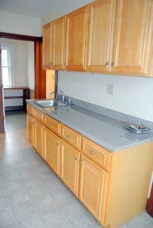 21 Maple Street Clinton, MA 01510 - Photo 9 of 17 a kitchen with stainless steel appliances granite countertop a sink a stove and white cabinets