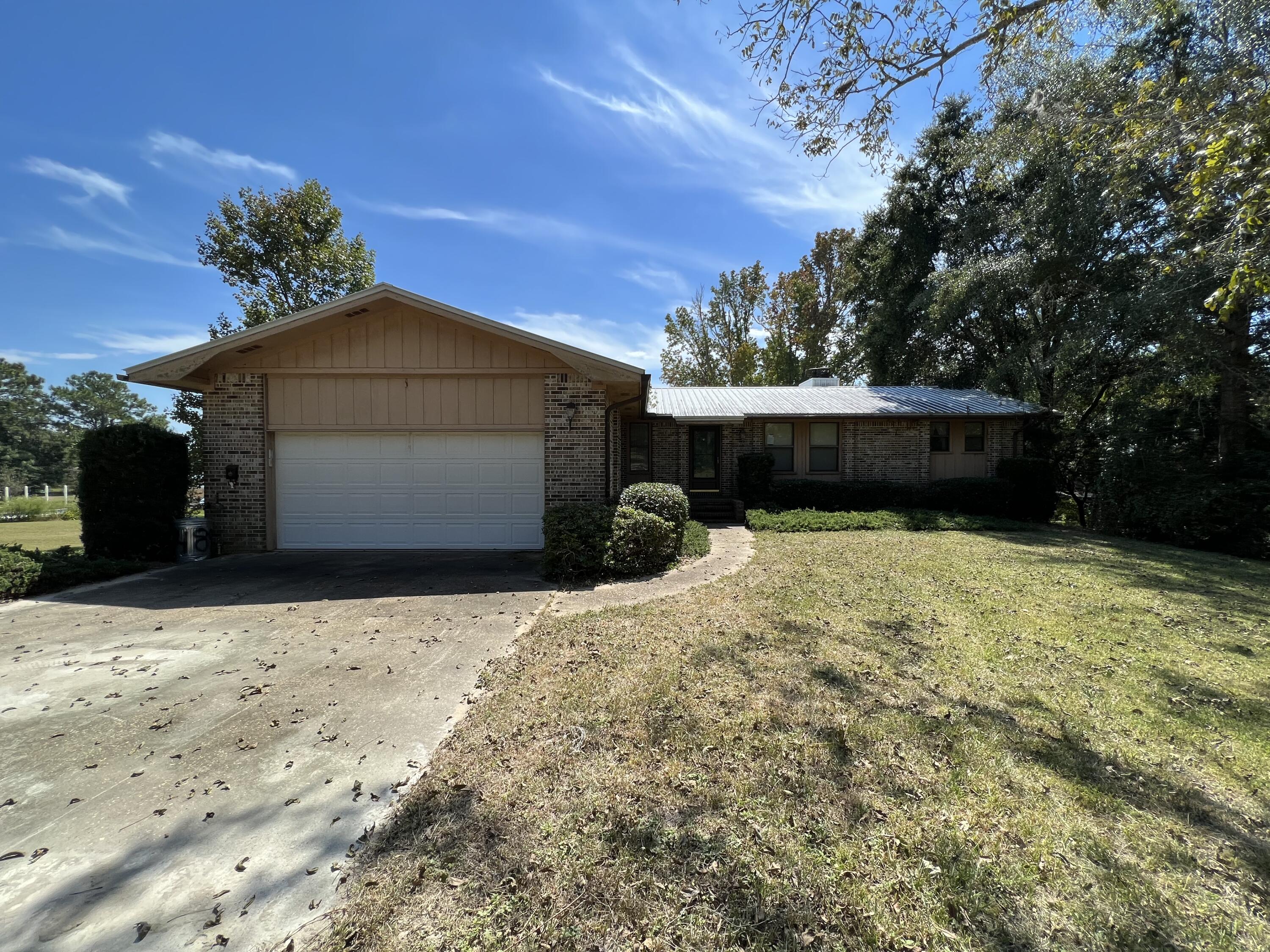 489 Paul Road DeFuniak Springs, FL 32433 - Photo 1 of 27 a front view of a house with a yard and garage
