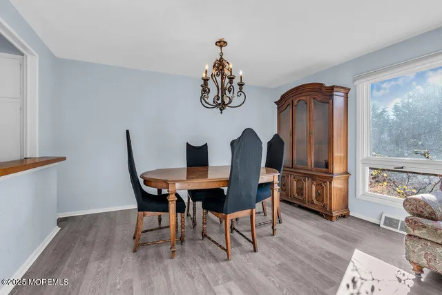 a dining room with furniture a window and wooden floor