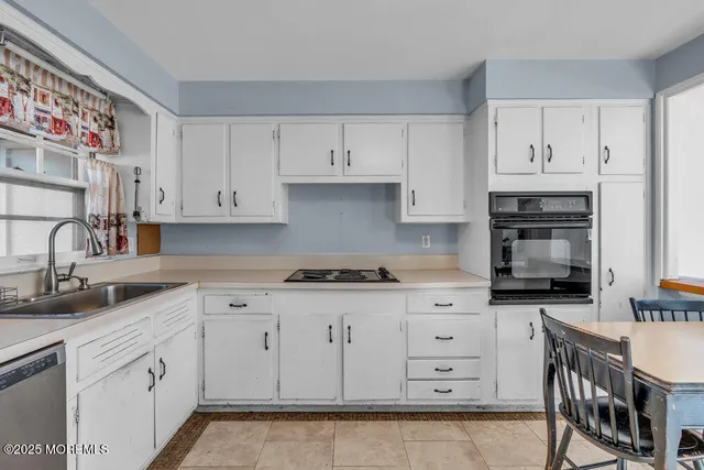 a kitchen with granite countertop white cabinets and stainless steel appliances