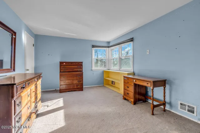 a view of a bedroom with furniture and a window