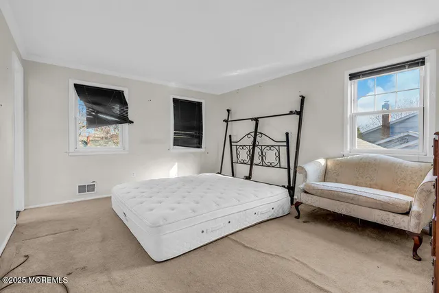 a bedroom with a bed a couch and dresser