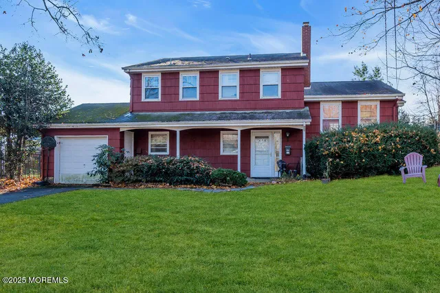 a front view of a house with a yard and trees