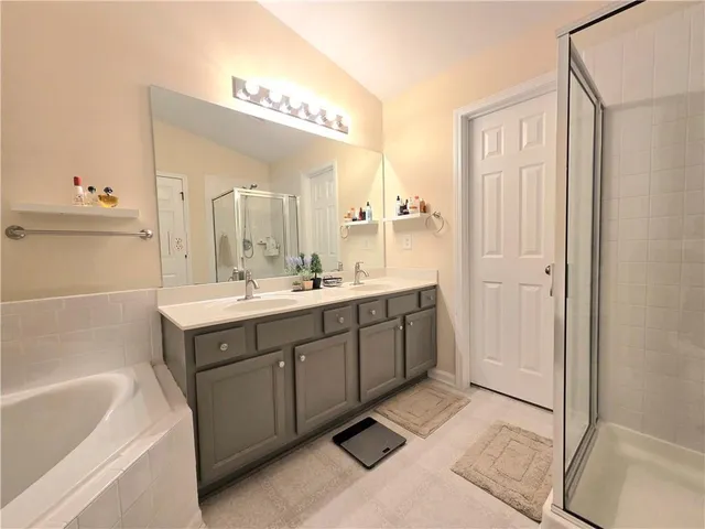a spacious bathroom with a double vanity sink a mirror and a bathtub