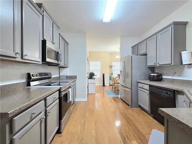 a kitchen with stainless steel appliances granite countertop a stove refrigerator sink and cabinets