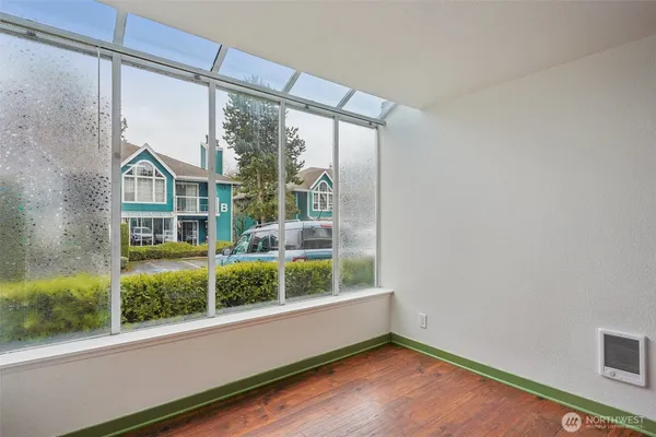 an empty room with wooden floor and windows