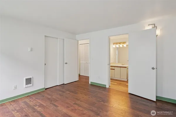 a view of empty room with wooden floor and window