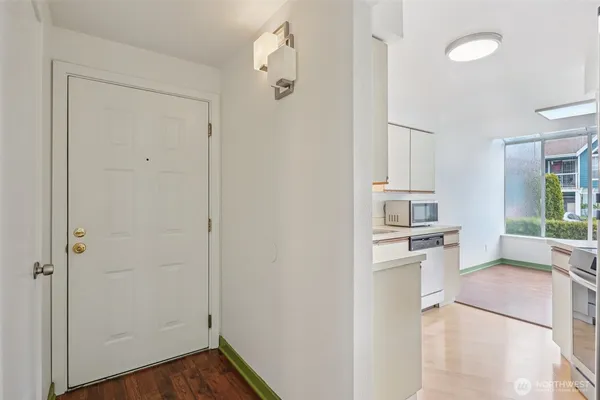a view of a kitchen with white cabinets and wooden floor
