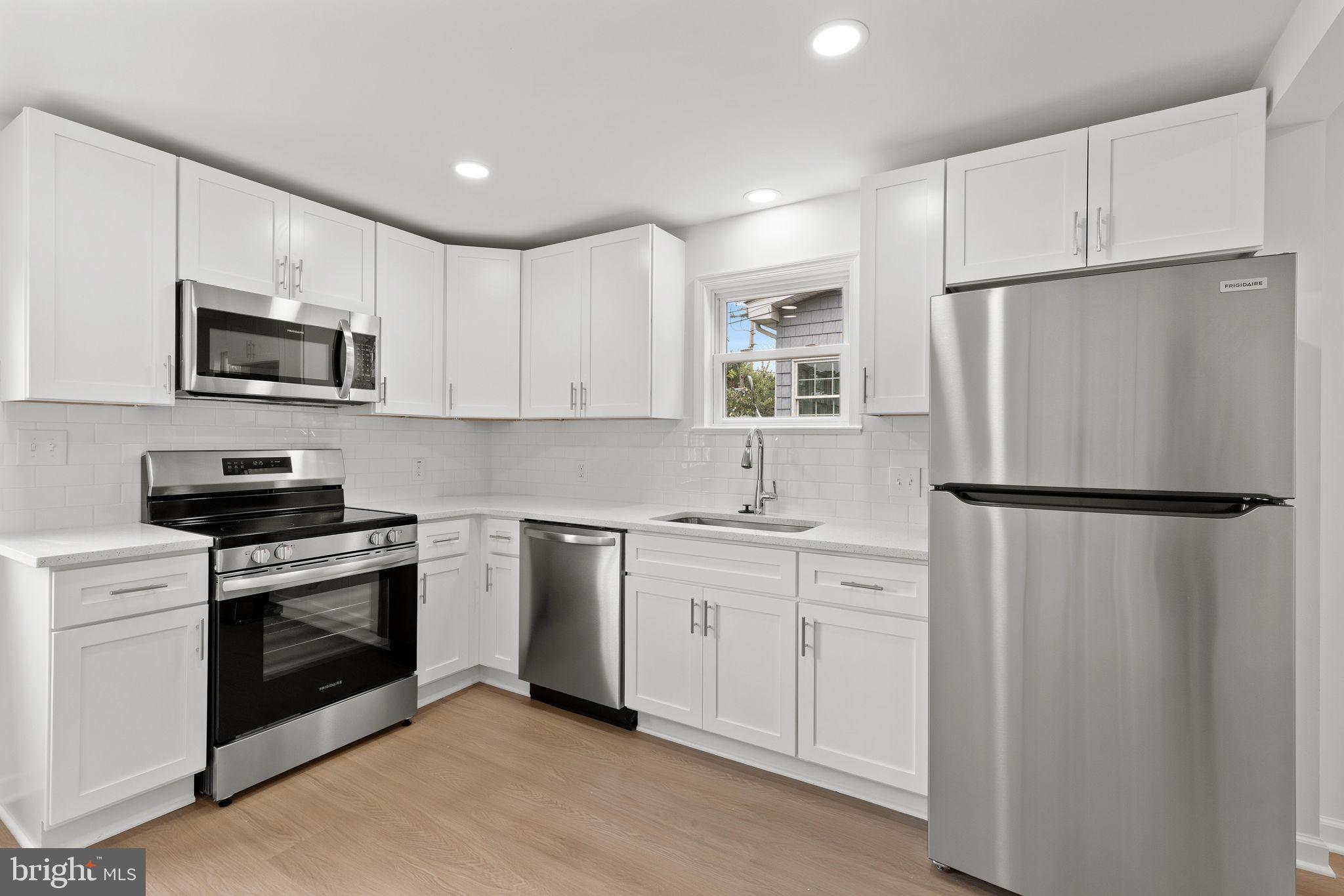 554 Compass Road East Baltimore, MD 21220 - Photo 10 of 24 a kitchen with white cabinets and stainless steel appliances