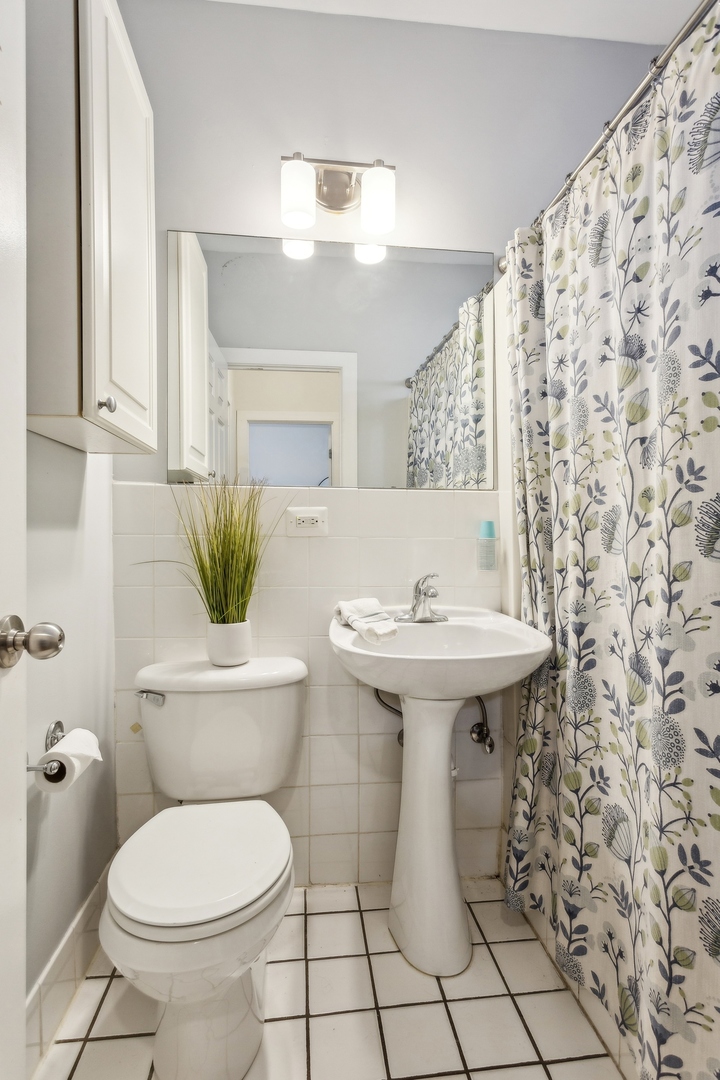 7025 North Sheridan Road, Unit 3N Chicago, IL 60626 - Photo 9 of 14 a bathroom with a sink toilet and mirror