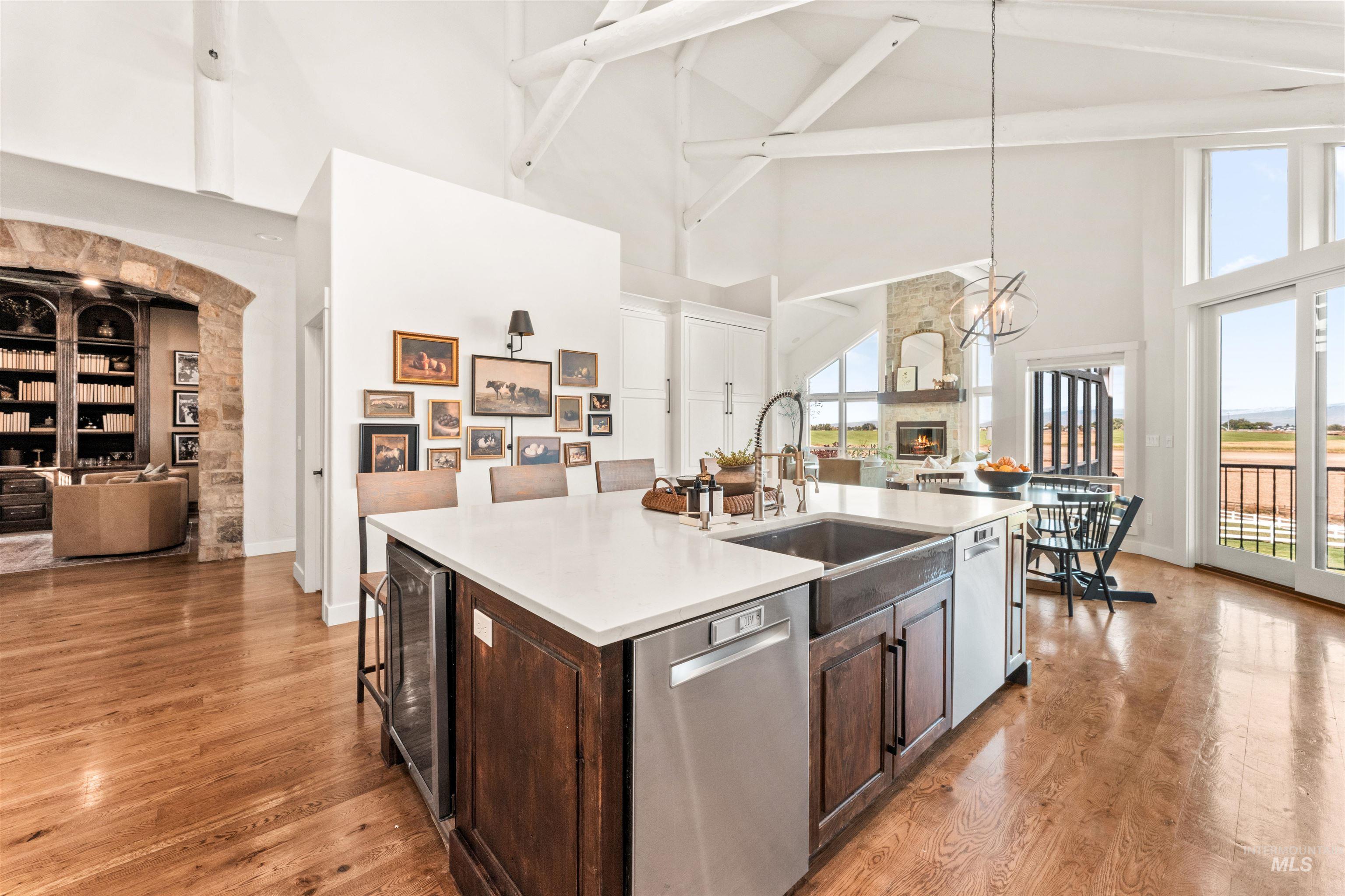 4262 South Rustler Lane Meridian, ID 83642 - Photo 50 of 50 Kitchen featuring dark brown cabinetry, open floor plan, dishwasher, a kitchen island with sink, and high vaulted ceiling