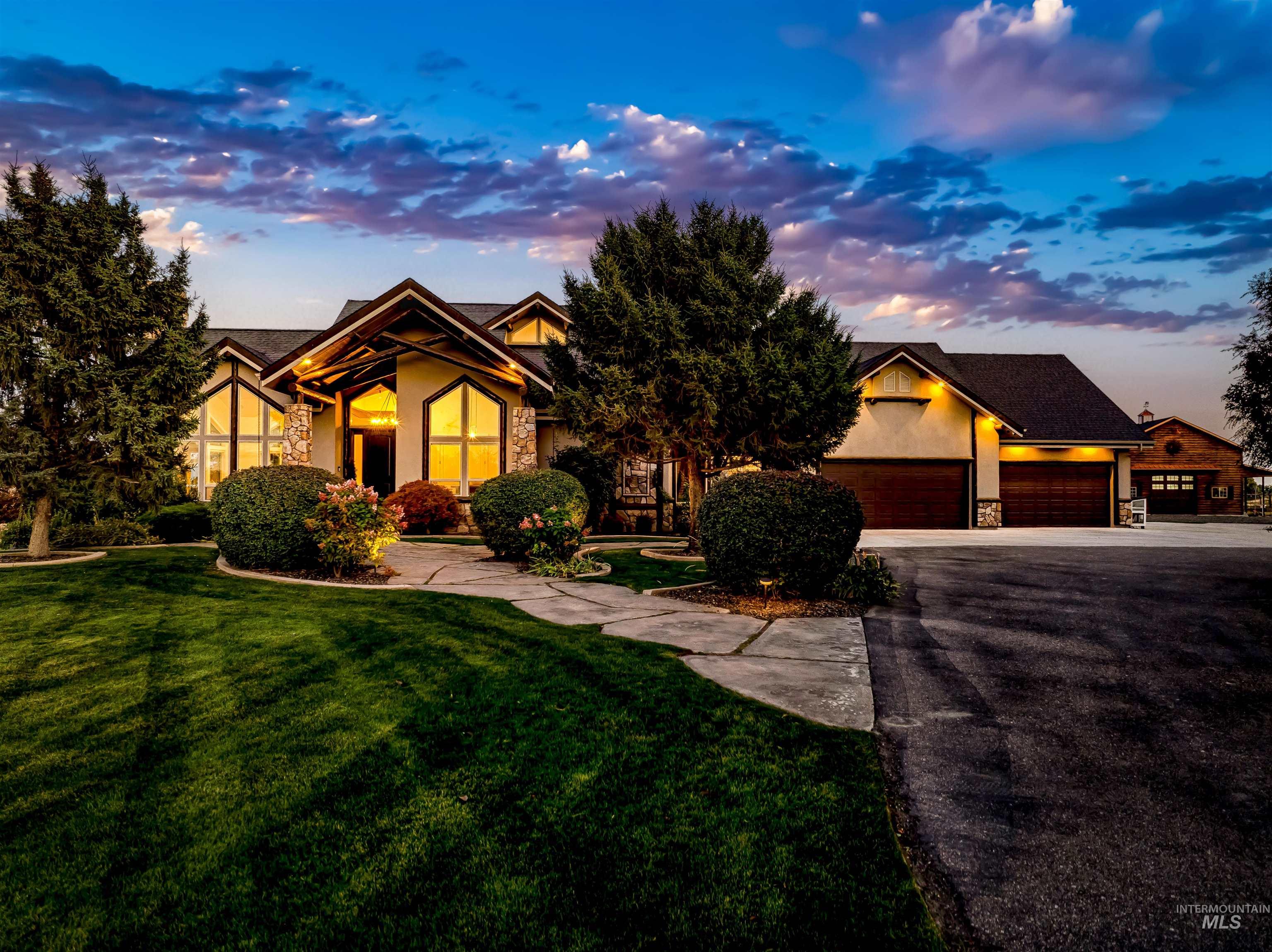 4262 South Rustler Lane Meridian, ID 83642 - Photo 4 of 50 View of front of home with stone siding, a front lawn, driveway, and stucco siding