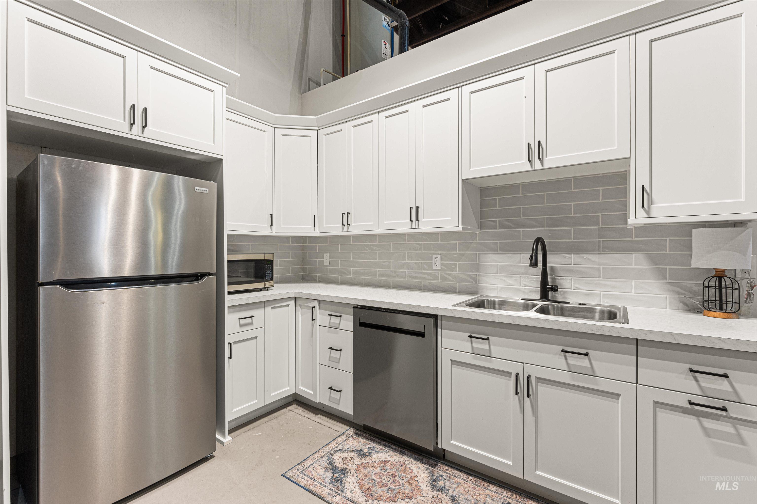 4262 South Rustler Lane Meridian, ID 83642 - Photo 41 of 50 Kitchen featuring stainless steel appliances, white cabinetry, tasteful backsplash, and light stone counters