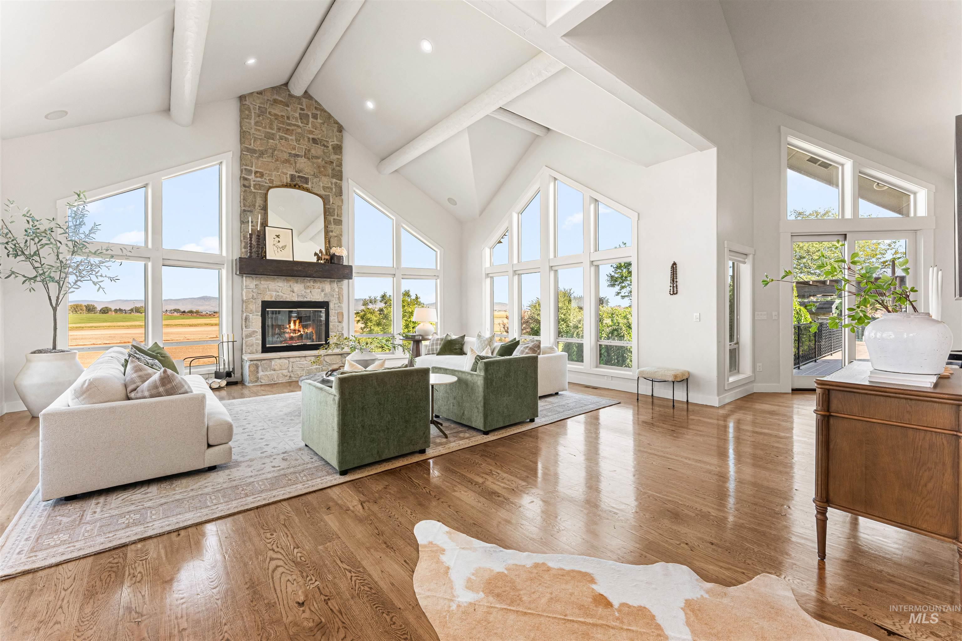 4262 South Rustler Lane Meridian, ID 83642 - Photo 6 of 50 Living room featuring high vaulted ceiling, hardwood / wood-style floors, healthy amount of natural light, a fireplace, and beamed ceiling