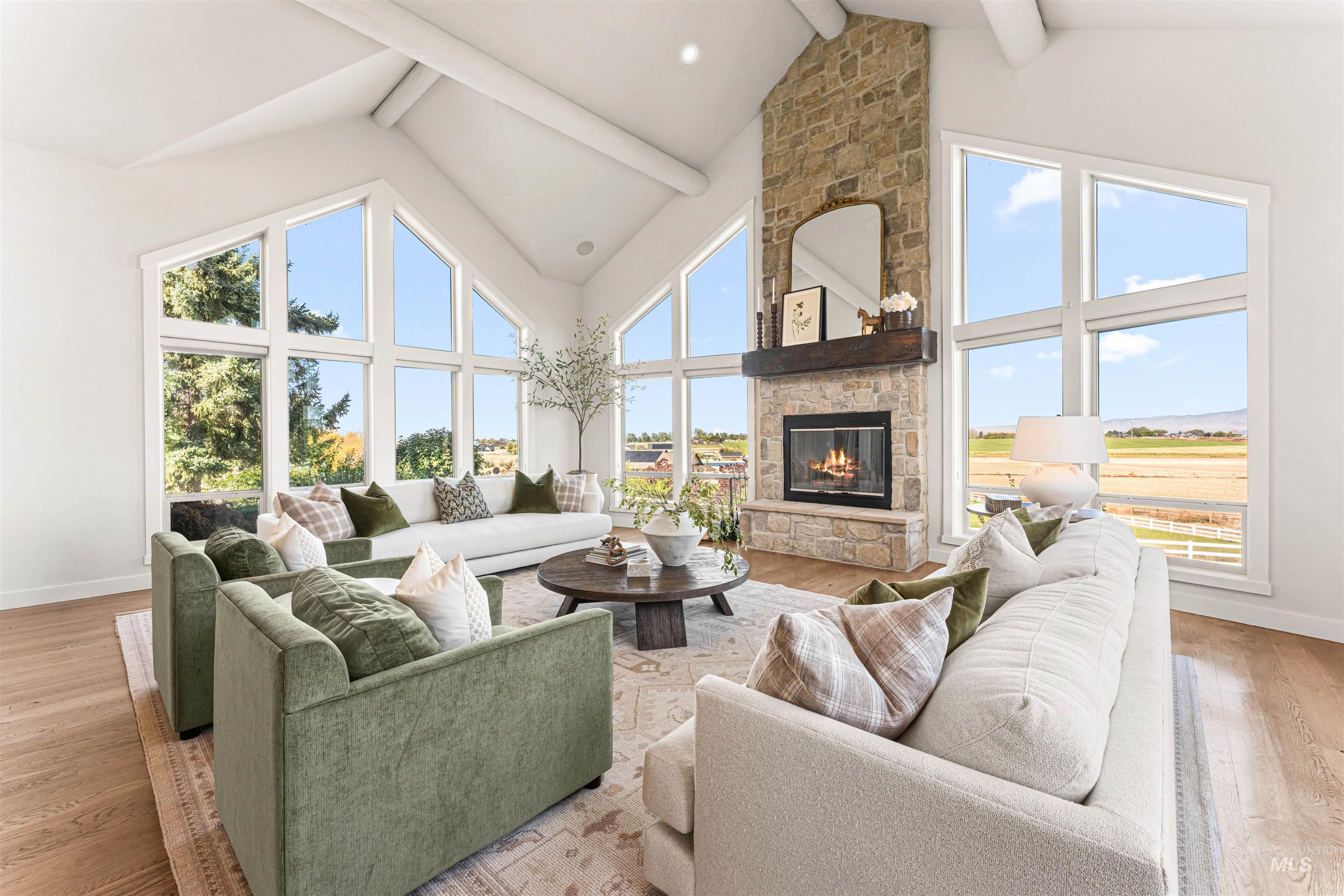 4262 South Rustler Lane Meridian, ID 83642 - Photo 7 of 50 Living area with light wood-style flooring, high vaulted ceiling, a fireplace, and beamed ceiling
